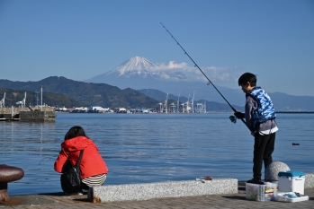 富士山を背景に釣りをする少年