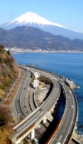 さった峠から道路、駿河湾、富士山が見えている