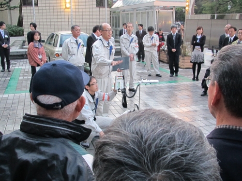 庁舎前で参加者に放射能測定の説明をする職員の写真