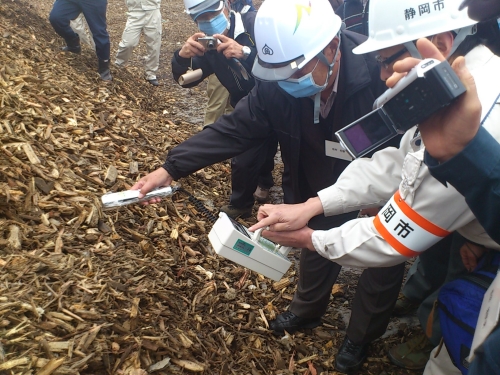 砕かれた木材の放射能を測定する参加者の写真